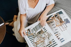 Casually dressed woman flipping through a modern interior design magazine for luxury homes in Bergen County